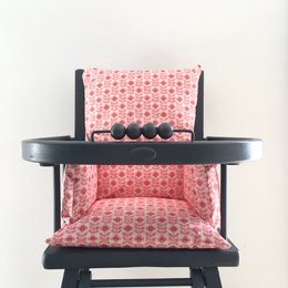 Plush pink cushion with floral pattern for a baby highchair. Comfortable and stylish addition to a baby's feeding chair.