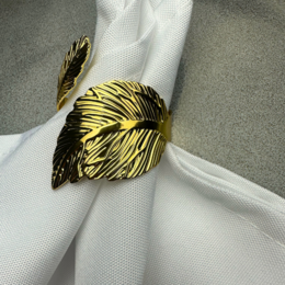 Elegant gold-colored napkin ring with feather-like design, suitable for formal table settings.