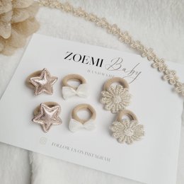 Mini hair ties in neutral colors, including beige and white stars and floral shapes.