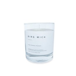 Organic scented candle in a clear glass container with the text "BIRG MICH" printed on it. The candle has a simple, minimalist design and appears to be a white or light-colored wax.