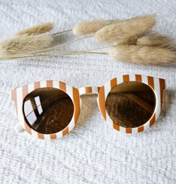  Striped beige/camel children's sunglasses with UV400 protection. The sunglasses have a round shape and a striped pattern.