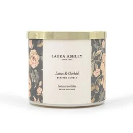 Tall, round scented candle with floral fragrance of lotus and orchid, presented in a decorative glass container.