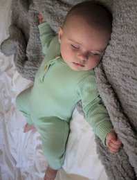 Green ribbed romper for baby, available in sizes 0-3 months to 12-18 months. Made of soft, comfortable material with a cozy, relaxed fit.