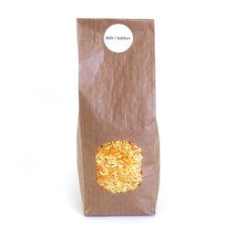 Assorted rice mix in a brown paper bag, containing a variety of yellow, orange, and white rice grains.