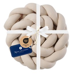 Braided beige bed bumper, knitted in a circular design, suitable for decorating a child's room.