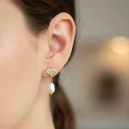  Elegant pearl drop earrings with a delicate gold-toned shell design, perfect for adding a touch of sophistication to any outfit.