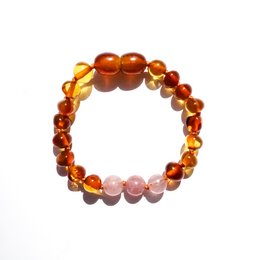 This Baltic natural amber baby bracelet/anklet features a mix of amber and rose quartz beads in a leadership design. The bracelet is made for kids and has a warm, earthy color palette.