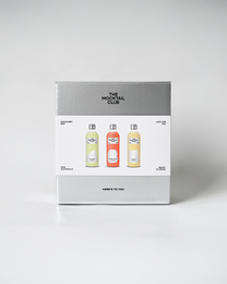A gift set containing three non-alcoholic mocktail mixers in various flavors, including citrus, berry, and tropical.