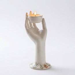  Cream ceramic hand-shaped candle holder, open palm design, holds tealights, decorative sculptural piece, modern minimalist style.