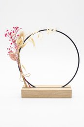 Circular dried flower hoop with terra earth and blush colored floral accents, mounted on a wooden base.