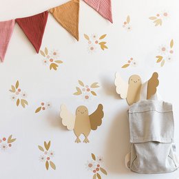 Decorative chick-shaped wall hanger for kids' clothing. Made of wood with a cute, whimsical design featuring wings and a smiling face. Ideal for hanging children's garments, accessories, or decor in a nursery or playroom.