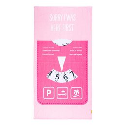 A pink beach towel with the text "SORRY I WAS HERE FIRST" and a parking disc design. The towel is suitable for beach use and features a playful and humorous design.