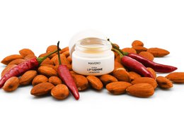 Lip booster and lip care product with almond oil, shea butter, beeswax, and capsaicin for moisturizing and plumping lips.