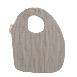 Beige bib with a soft, textured fabric. Designed for infants and toddlers to keep them clean and comfortable during feeding.