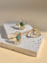  Adjustable oval ring in stainless steel with a sun and stone pattern, available in turquoise, white, and green color variants.