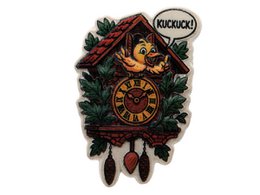 A small, white, fluffy sheep figurine with a round body and short legs, sitting on a grassy base.