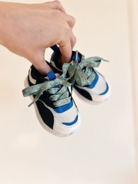 Green shoelaces with small floral pattern, suitable for children's shoes.