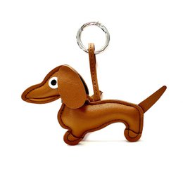 Leather keychain in the shape of a brown and silver dachshund dog, with a metal ring for attaching to keys.