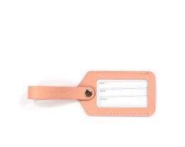 A pink luggage tag with a window for displaying travel information. The tag is made of a durable material and has a sturdy strap for attaching to luggage.