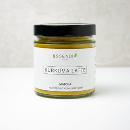 Turmeric latte matcha powder in a glass jar. The powder is a vibrant yellow-green color, indicating the presence of turmeric and matcha. This product is suitable for making turmeric lattes or other beverages.