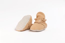 Soft, cream-colored baby shoes with a bow detail, suitable for infants aged 0-24 months.