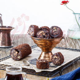  Chocolate-coated brownie bites with nuts, in a bowl on a wooden surface.