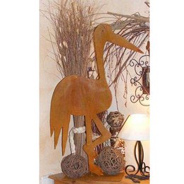 Vintage garden figurine of a patina stork, approximately 80cm tall, mounted on a base plate. The stork sculpture has a rustic, weathered appearance, complemented by natural elements like dried branches and foliage.