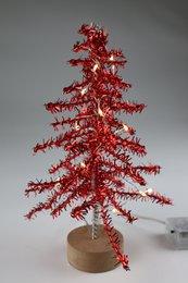  A tall, red, glittery metal Christmas tree with 100 LED lights and a wooden base.
