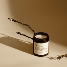 Tall, round, black candle with a wooden wick. Scented candle with a warm, earthy fragrance.