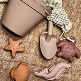 Dusty apricot-colored beach set with starfish, turtle, and shovel toys for kids' bath time fun.