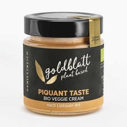 Piquant taste bio veggie cream in a glass jar with a black and gold label. The cream appears to be a savory, spreadable product made from natural, organic ingredients.