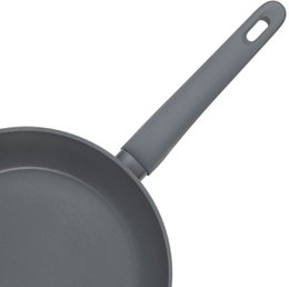 A round, black cast iron frying pan with a metal handle. The pan is suitable for all heat sources and is PFAS-free.