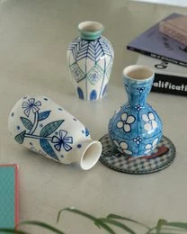 Blue and white ceramic vases, botanical floral patterns, set of three, varying shapes and sizes, decorative.