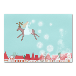 Whimsical Christmas card with a reindeer blowing snow bubbles over a snowy village scene.