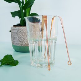 Copper tongue scraper with a long handle for effective oral care.