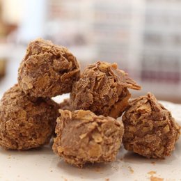 Delicate crepe lace-wrapped praline truffles in a 100g sachet. Rich, indulgent chocolate-coated confections with a soft, creamy center.