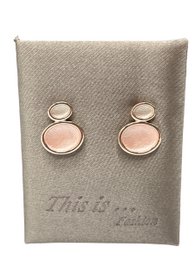  Elegant hoop earrings with a delicate pink stone centerpiece. Crafted with a modern, minimalist design.