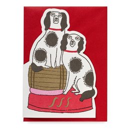 Two spotted dogs sitting on a red platform with a barrel-shaped object. The dogs have distinctive features and appear to be the focus of the image.