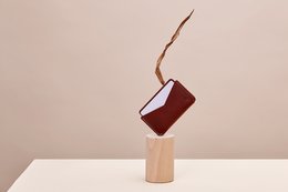 Slim, minimalist leather wallet in a deep burgundy color with a sleek, rectangular shape.