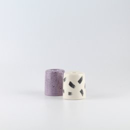 Ceramic candle holder in a patterned, lilac color with a unique shape.