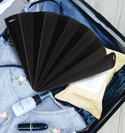  Black opaque hand fan with pleated design.