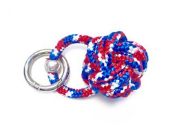 Patriotic-colored paracord keychain with a round, textured design in red, white, and blue.