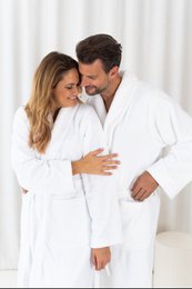  Soft, plush white bathrobe with shawl collar and belt. Ideal for lounging or post-shower comfort.