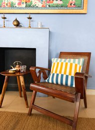 Soft, knitted cotton pillow cover in a vibrant striped pattern of blue, yellow, and white. Suitable for use on a couch or bed.