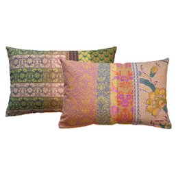 Decorative boho-style cushion with floral and geometric patterns in shades of pink, green, and gold.