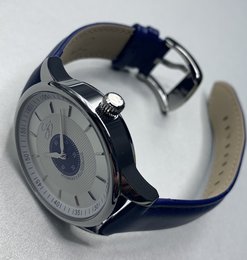 Stainless steel watch with navy blue leather strap, featuring a round analog dial with silver-tone hands and markers.
