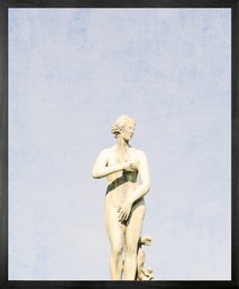Framed canvas wall art featuring a classical nude statue against a pale blue sky background. The artwork has a minimalist, modern aesthetic.