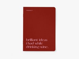 Burgundy-colored notebook with the text "Brilliant ideas I had while drinking wine" printed on the cover.