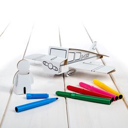 A wooden toy plane model with colored pencils and markers on a wooden surface.