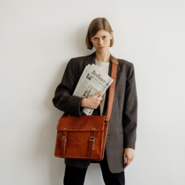  Leather briefcase with a classic design, available in XL and M sizes. Features a structured shape, durable construction, and a versatile brown color.